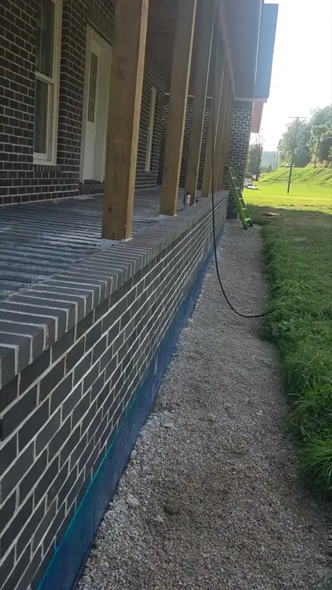 Timber porch posts standing on a capped brick porch wall.