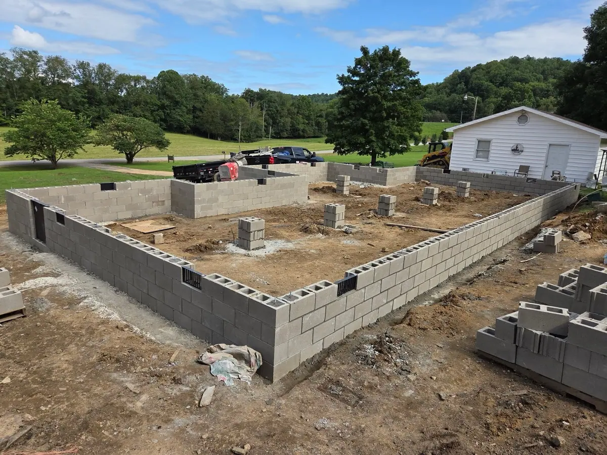 Concrete block foundation walls laid out for a new house, with block piers in the crawl space.